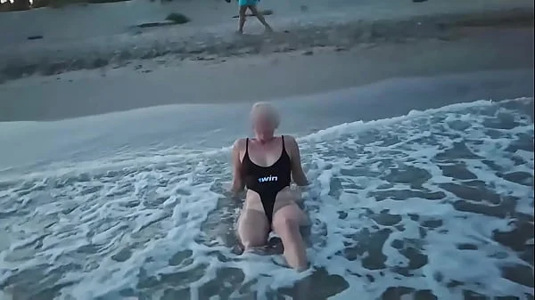 Blonde shows tits and sucks cock on a public beach